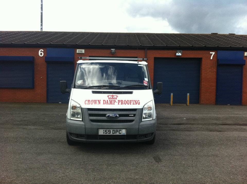 A Crown Damp-Proofing van parked outside industrial units