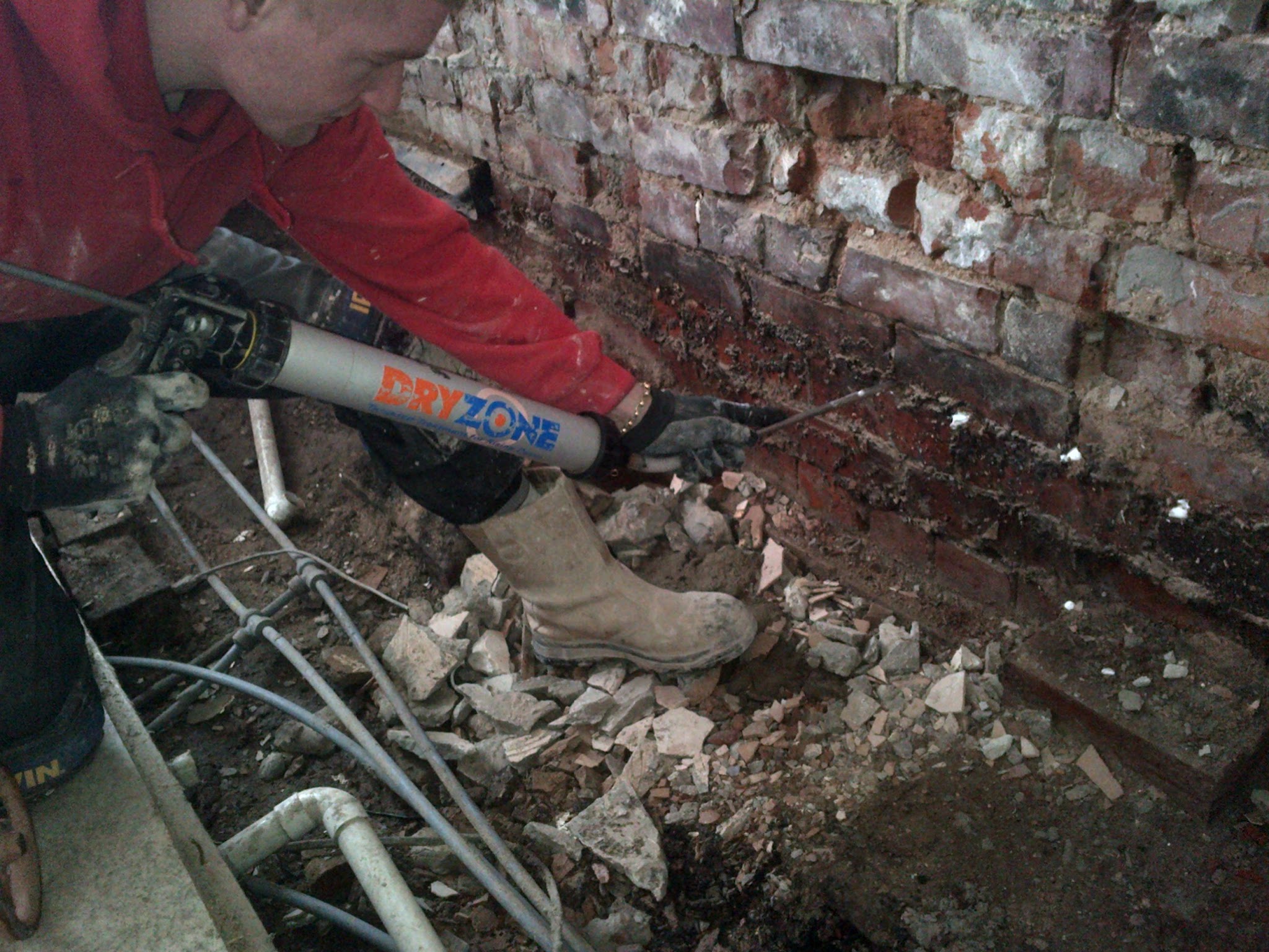 Damp proof cream being injected into the mortar course of a brick wall